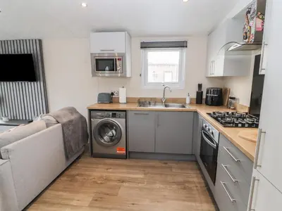 a kitchen with a sink and a washing machine at 24 Sherwood in Carnforth