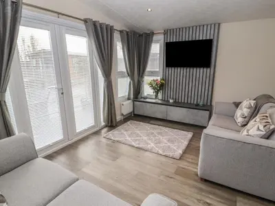 a living room with a couch and a flat screen tv at 24 Sherwood in Carnforth