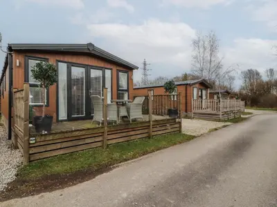 a tiny house with a deck and a table at 24 Sherwood in Carnforth