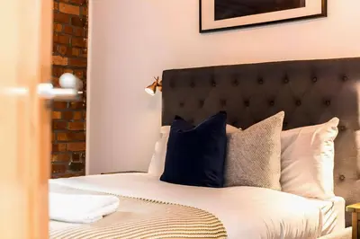 a bedroom with a bed with blue and white pillows at Bands Warehouse I in Liverpool