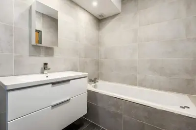 a bathroom with a white sink and a bath tub at Bands Warehouse I in Liverpool