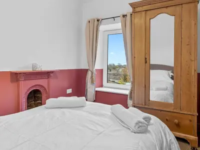 a white cat laying on a bed in a room with a window at Lovely 2 Bed With Pool Table Ulverston - Pass the Keys in Ulverston