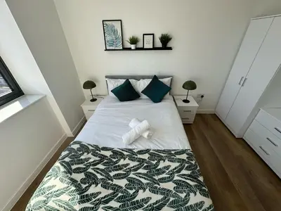 a bedroom with a bed and two night stands at Two Bedroom City View Apartment Liverpool by StaySavvy Accommodation in Liverpool