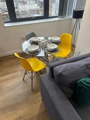 a living room with a table and yellow chairs at Two Bedroom City View Apartment Liverpool by StaySavvy Accommodation in Liverpool