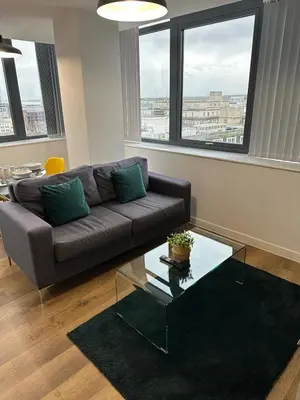 a living room with a couch and a glass table at Two Bedroom City View Apartment Liverpool by StaySavvy Accommodation in Liverpool