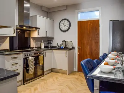 a kitchen with a table and a clock on the wall at The Sandcastle in Blackpool