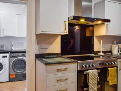 a kitchen with a stove top oven next to a dishwasher at The Sandcastle in Blackpool