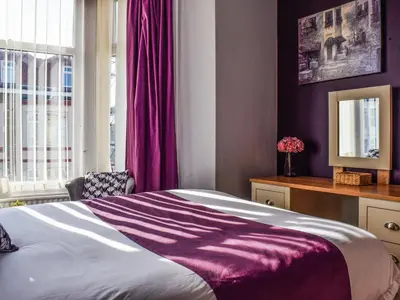 a bedroom with a bed with a purple blanket at The Sandcastle in Blackpool