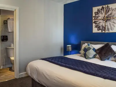 a bedroom with a bed with a blue wall at The Sandcastle in Blackpool