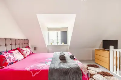 a bedroom with a pink bed and a television at Town house Anfield stadium in Liverpool