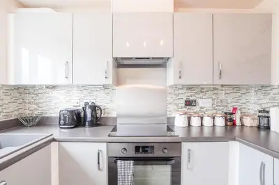 a kitchen with white cabinets and a stove top oven at Town house Anfield stadium in Liverpool