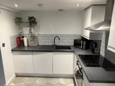 a kitchen with white cabinets and a sink at 5 Halifax House Apartment 7 in Liverpool