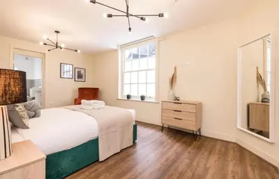 a bedroom with a large bed and a window at 71 Townhouse By Elite in Liverpool