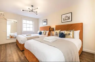 a bedroom with two beds and a mirror at 71 Townhouse By Elite in Liverpool