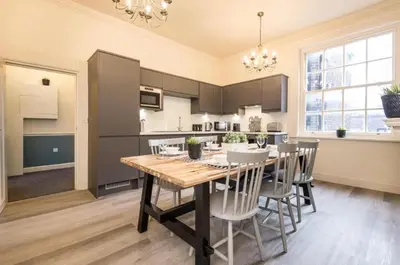a kitchen and dining room with a wooden table and chairs at 71 Townhouse By Elite in Liverpool