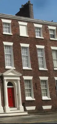 a brick building with a red door and windows at 71 Townhouse By Elite in Liverpool
