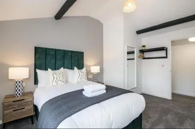 a bedroom with a large white bed with a green headboard at 91 Roscoe by Elite in Liverpool