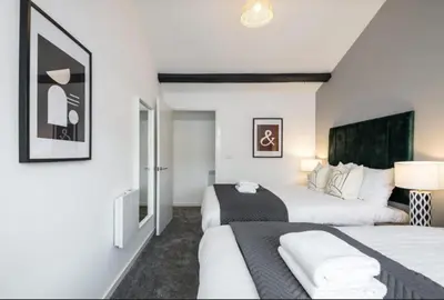 two beds in a room with white walls at 91 Roscoe by Elite in Liverpool