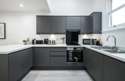a kitchen with black cabinets and a sink at 91 Roscoe by Elite in Liverpool