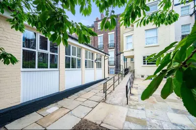 a walkway in front of two buildings at The Coach House by Elite in Liverpool