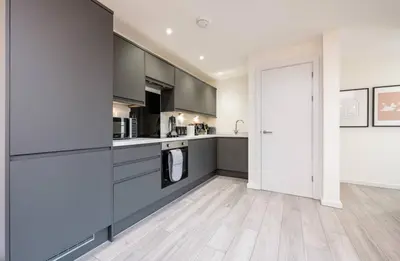 a kitchen with grey cabinets and a white door at The Coach House by Elite in Liverpool