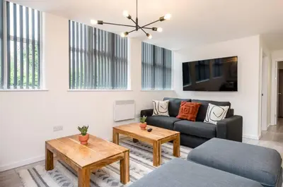 a living room with a couch and a table at The Coach House by Elite in Liverpool
