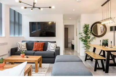 a living room with a blue couch and a table at The Coach House by Elite in Liverpool