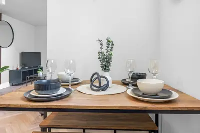 a dining room table with plates and wine glasses at St George's Quarter Stay - Modern City Centre Duplex - Perfect for Business & Leisure - FREE PARKING - WiFi Included - Close to transport links in Liverpool