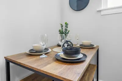 a dining room table with plates and wine glasses at St George's Quarter Stay - Modern City Centre Duplex - Perfect for Business & Leisure - FREE PARKING - WiFi Included - Close to transport links in Liverpool