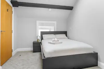 a bedroom with a black and white bed with two pillows at St George's Quarter Stay - Modern City Centre Duplex - Perfect for Business & Leisure - FREE PARKING - WiFi Included - Close to transport links in Liverpool