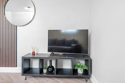 a living room with a black entertainment center with a television at St George's Quarter Stay - Modern City Centre Duplex - Perfect for Business & Leisure - FREE PARKING - WiFi Included - Close to transport links in Liverpool