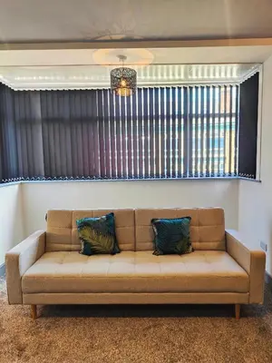 a couch with two pillows sitting in a living room at Ocean Breeze in Blackpool