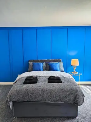 a bedroom with blue walls and a large bed at Ocean Breeze in Blackpool
