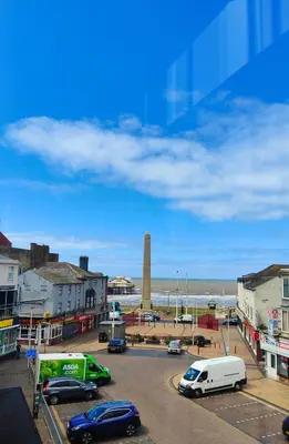 a street with cars parked in a parking lot near the ocean at Ocean Breeze in Blackpool