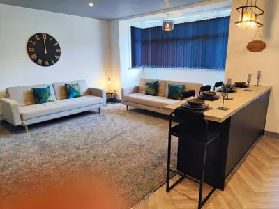 a living room with a couch and a clock on the wall at North View in Blackpool