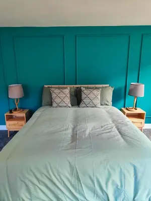 a bedroom with a large bed with blue walls at North View in Blackpool