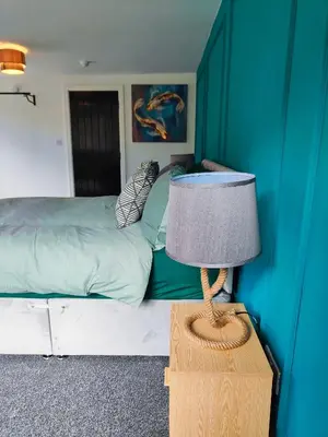 a bedroom with a bed and a table with a lamp at North View in Blackpool