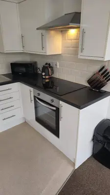 a kitchen with white cabinets and a tea kettle on the stove at Irwell Chambers by L3 Apartments in Liverpool