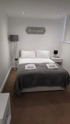 a bedroom with a large bed with a sign on the wall at Irwell Chambers by L3 Apartments in Liverpool