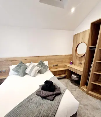 a bedroom with a bed and a desk with a mirror at The Old Bakehouse in Ulverston