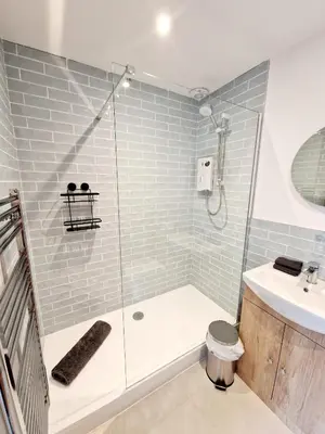 a bathroom with a shower and a toilet and a sink at The Old Bakehouse in Ulverston