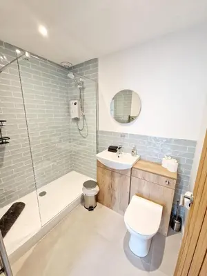 a bathroom with a toilet and a sink and a shower at The Old Bakehouse in Ulverston