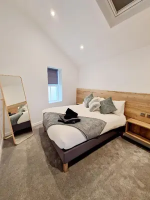 a bedroom with a large bed and a mirror at The Old Bakehouse in Ulverston