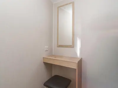 a bathroom with a wooden vanity with a mirror and a stool at FGH Holidays in Morecambe