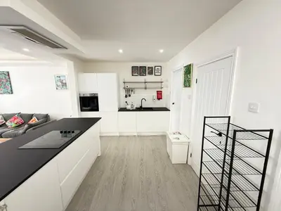 a kitchen and living room with a black counter top at Holm from Home sleeps 10 in Blackpool