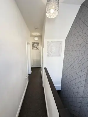 a hallway with a staircase with white walls and a stair case at Holm from Home sleeps 10 in Blackpool