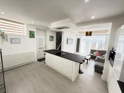 a kitchen and living room with a black counter top at Holm from Home sleeps 10 in Blackpool