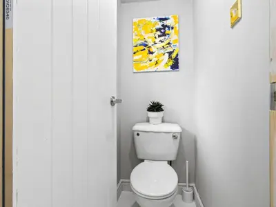 a bathroom with a toilet and a painting on the wall at Spacious 3 Bedroom Home in Aintree in Liverpool