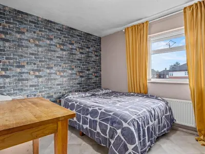 a bedroom with a bed and a brick wall at Spacious 3 Bedroom Home in Aintree in Liverpool