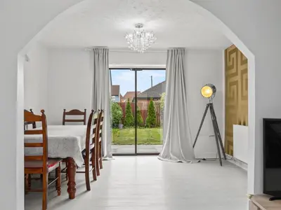 a dining room with a table and a chandelier at Spacious 3 Bedroom Home in Aintree in Liverpool